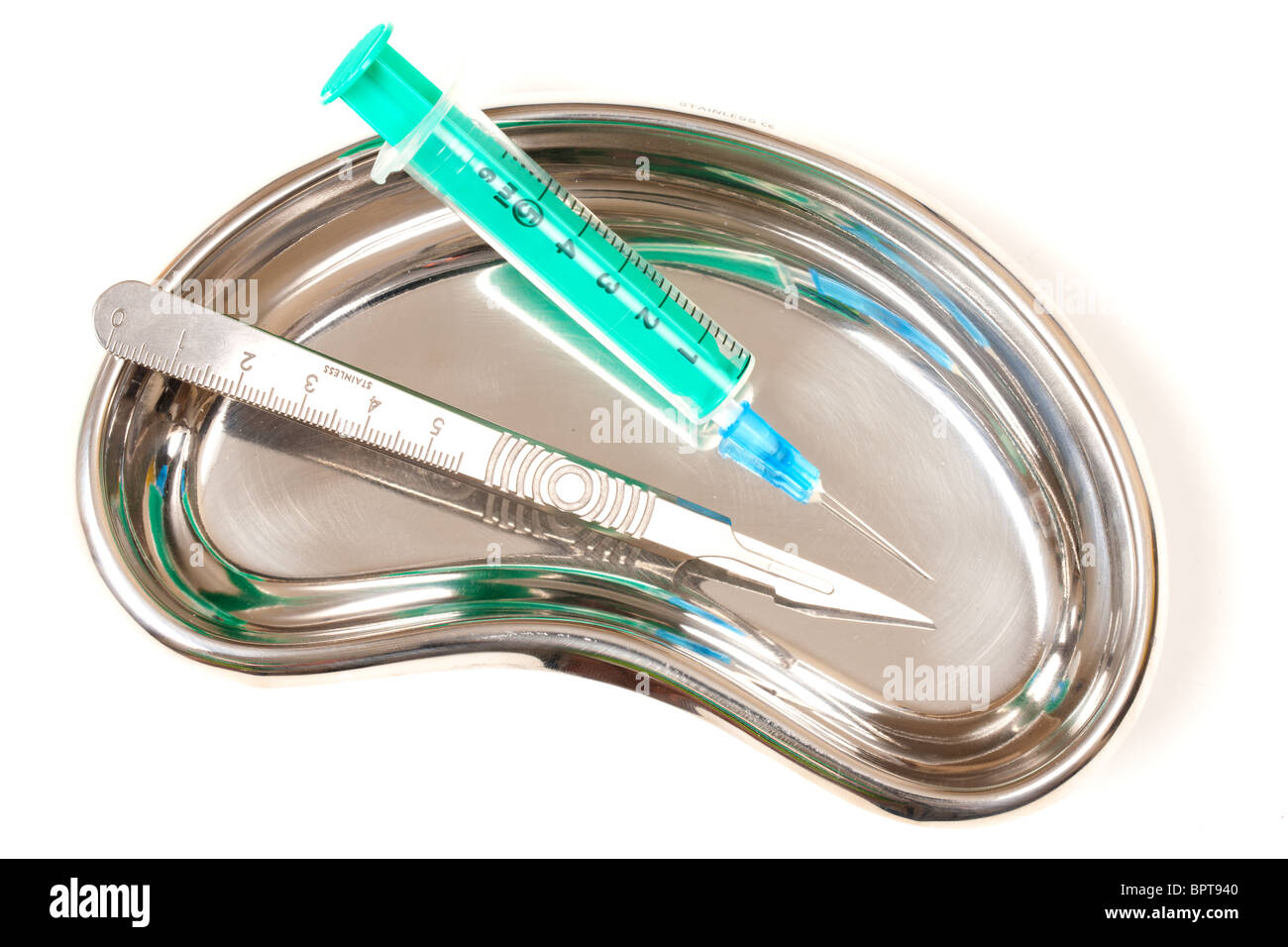 Green Syringes and scalpel in a stainless steel kidney dish Stock Photo