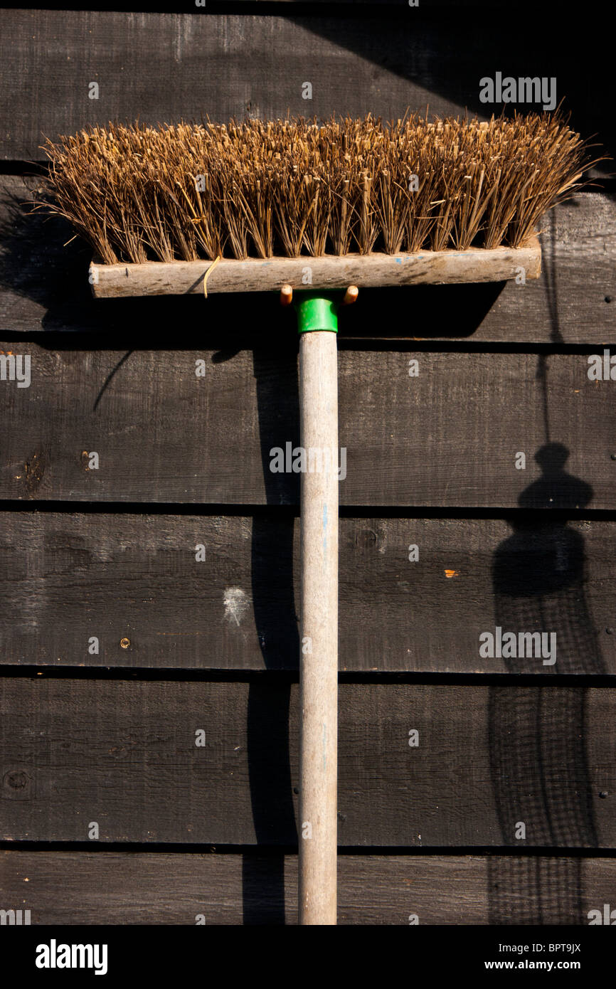 A brush hangs against a wooden backdrop Stock Photo