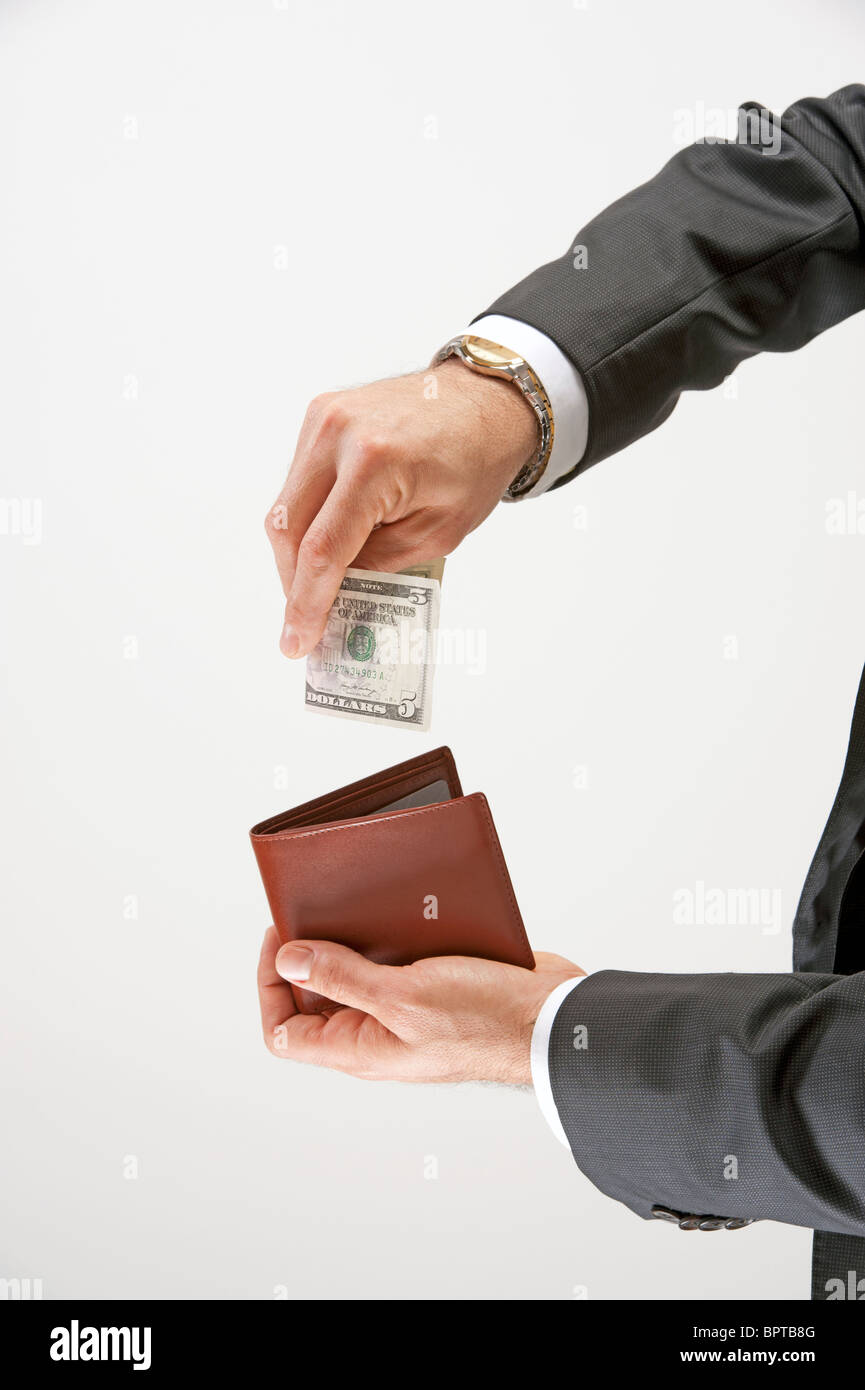 Man puts money into his wallet Stock Photo Alamy