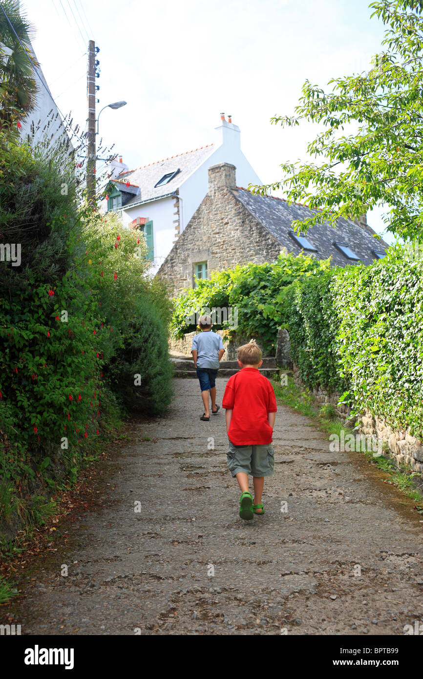 two boys walking up Rue Neuve, Ile aux Moines, Golfe du Morbihan, Brittany, Bretagne, France Stock Photo
