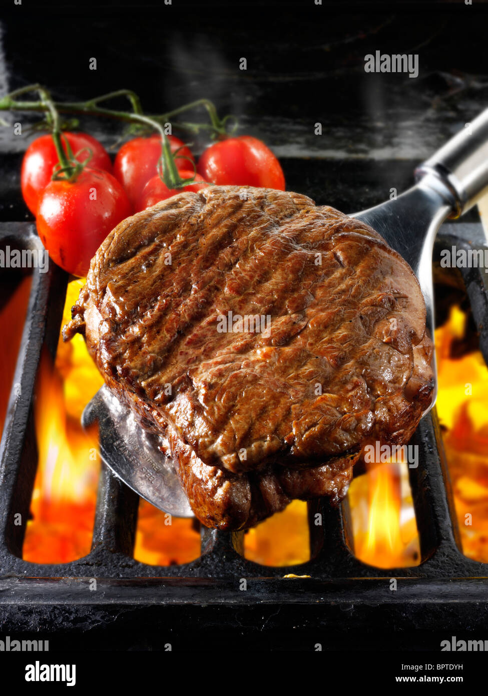 Beef fillet steaks & tomatoes being cooked on a bbq. Meat food photos, pictures & images. Stock Photo