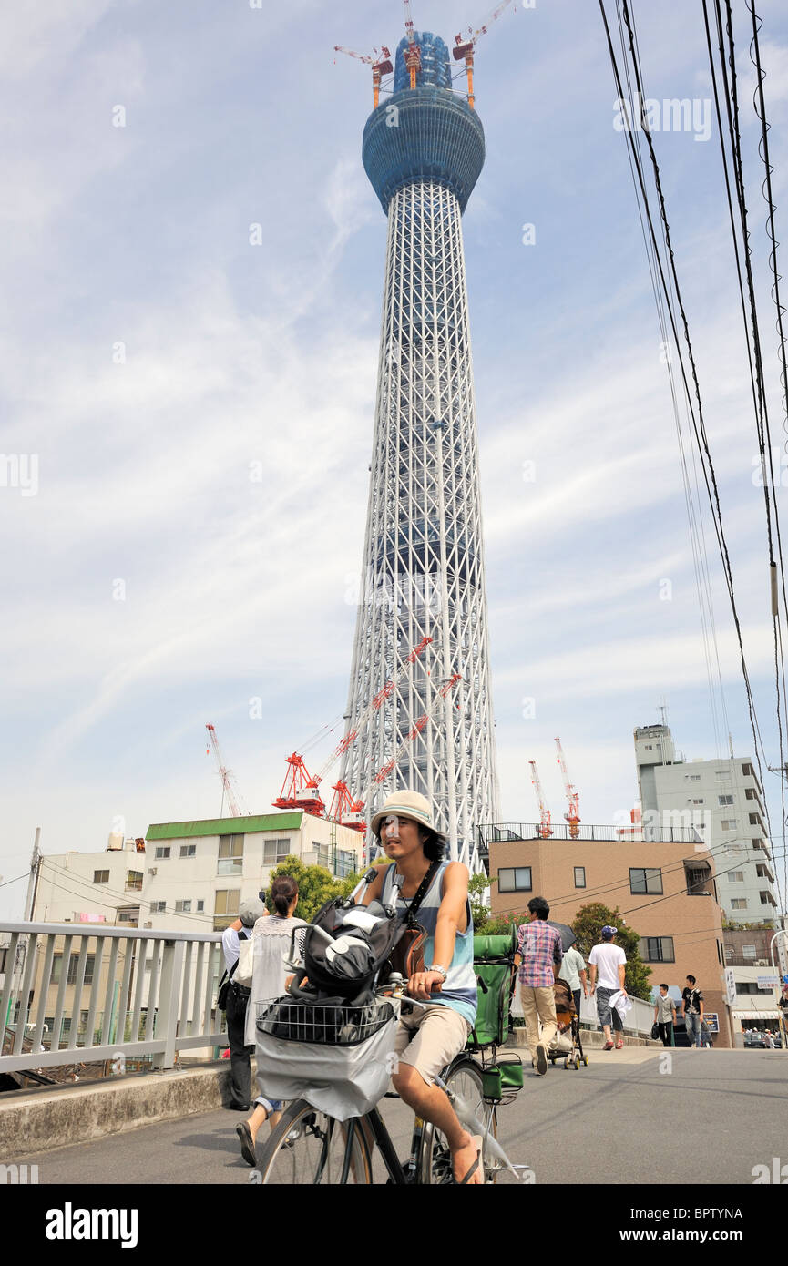 Tokyo, Japan, A japanese man riding on a bicycle in daito area with Tokyo Sky Tree Stock Photo