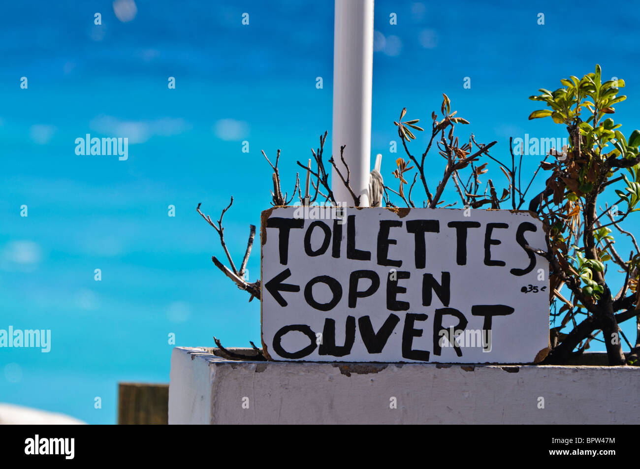 Sign indicating that seaside toilets are open in French and English: 'Toilettes open ouvert' Stock Photo