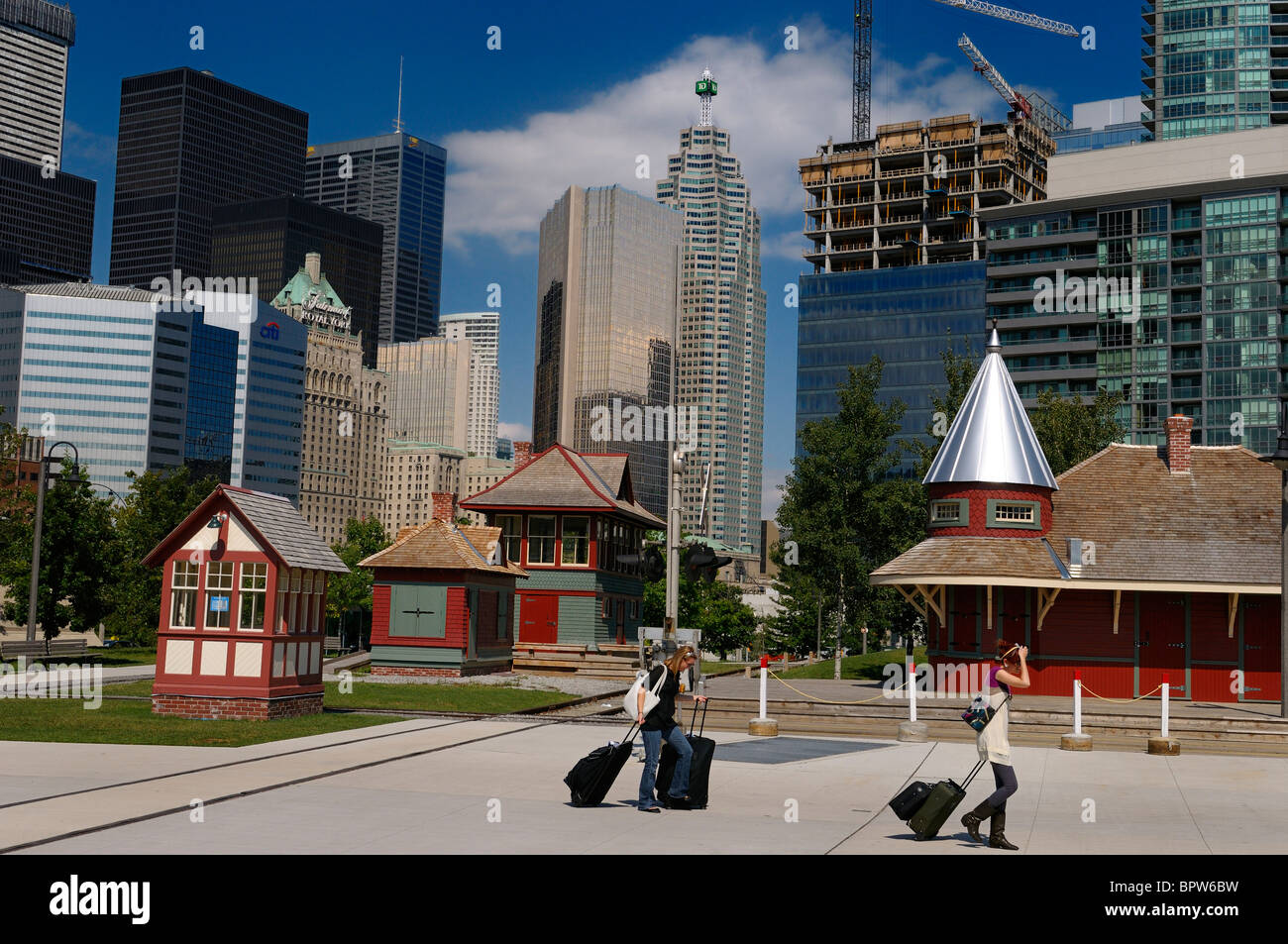Tourists with baggage at the historic railway museum at Roundhouse Park with Toronto skyline Stock Photo