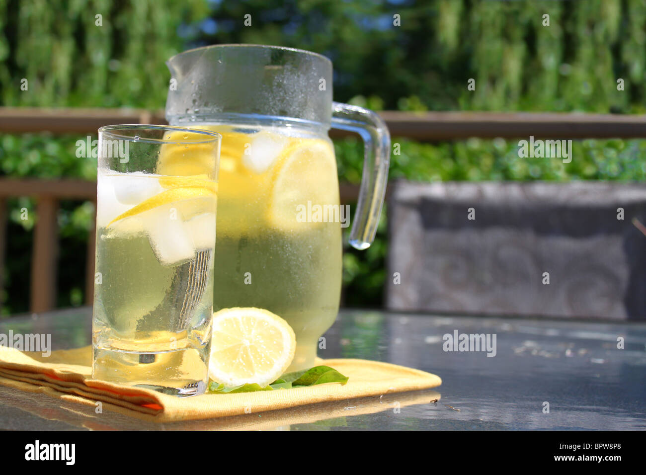 https://c8.alamy.com/comp/BPW8P8/pitcher-of-emonade-in-jar-and-glass-with-lemons-ice-on-outdoor-table-BPW8P8.jpg