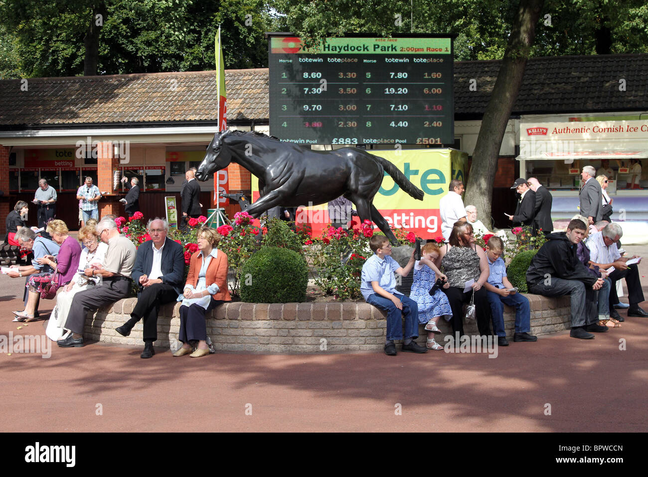 People seated around the gardens and Red Rum Statue at the Betfred Sprint Cup Race meeting, Haydock Park Racecourse Saturday 4th September, 2010 Stock Photo