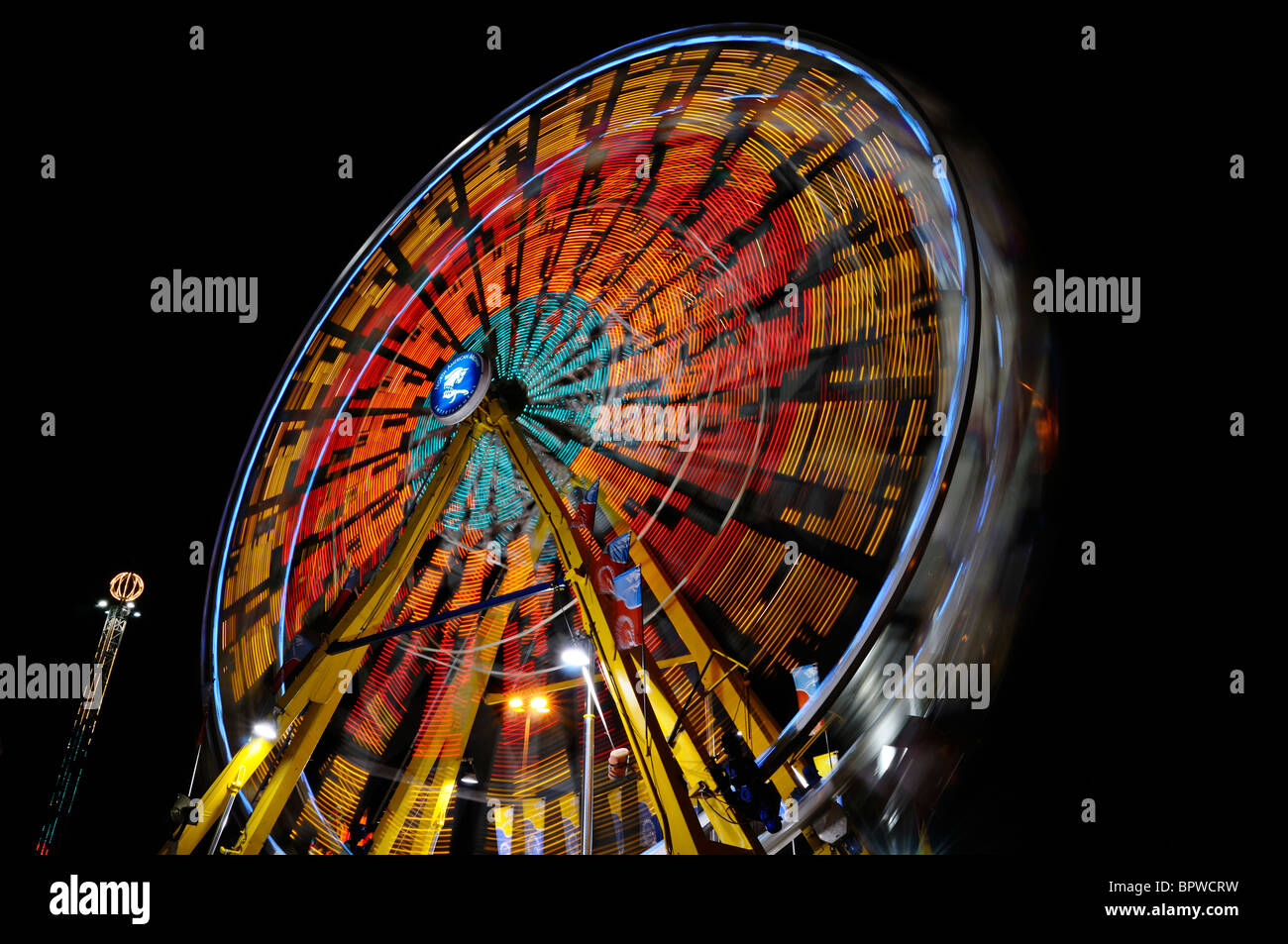 Light streaks from the spinning Ferris Wheel at night at the Toronto Canadian National Exhibition CNE funfair midway fairgrounds Stock Photo