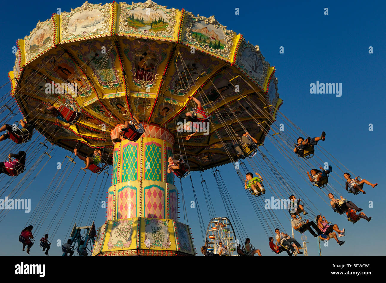 Children on the classic spinning swing ride at sunset at the Toronto CNE Stock Photo