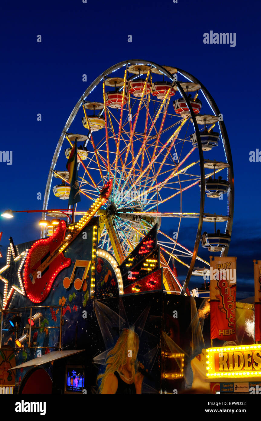 Music entertainment and Ferris Wheel rides at the Canadian National Exhibition CNE funfair midway fairgrounds Toronto at dusk Stock Photo