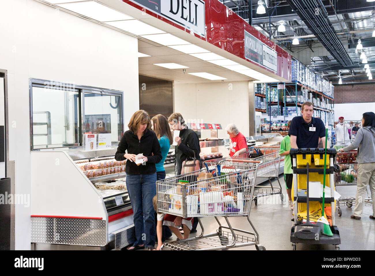 customers with large shopping carts cluster around the gleaming cold chests in the deli section of a Costco USA store Stock Photo