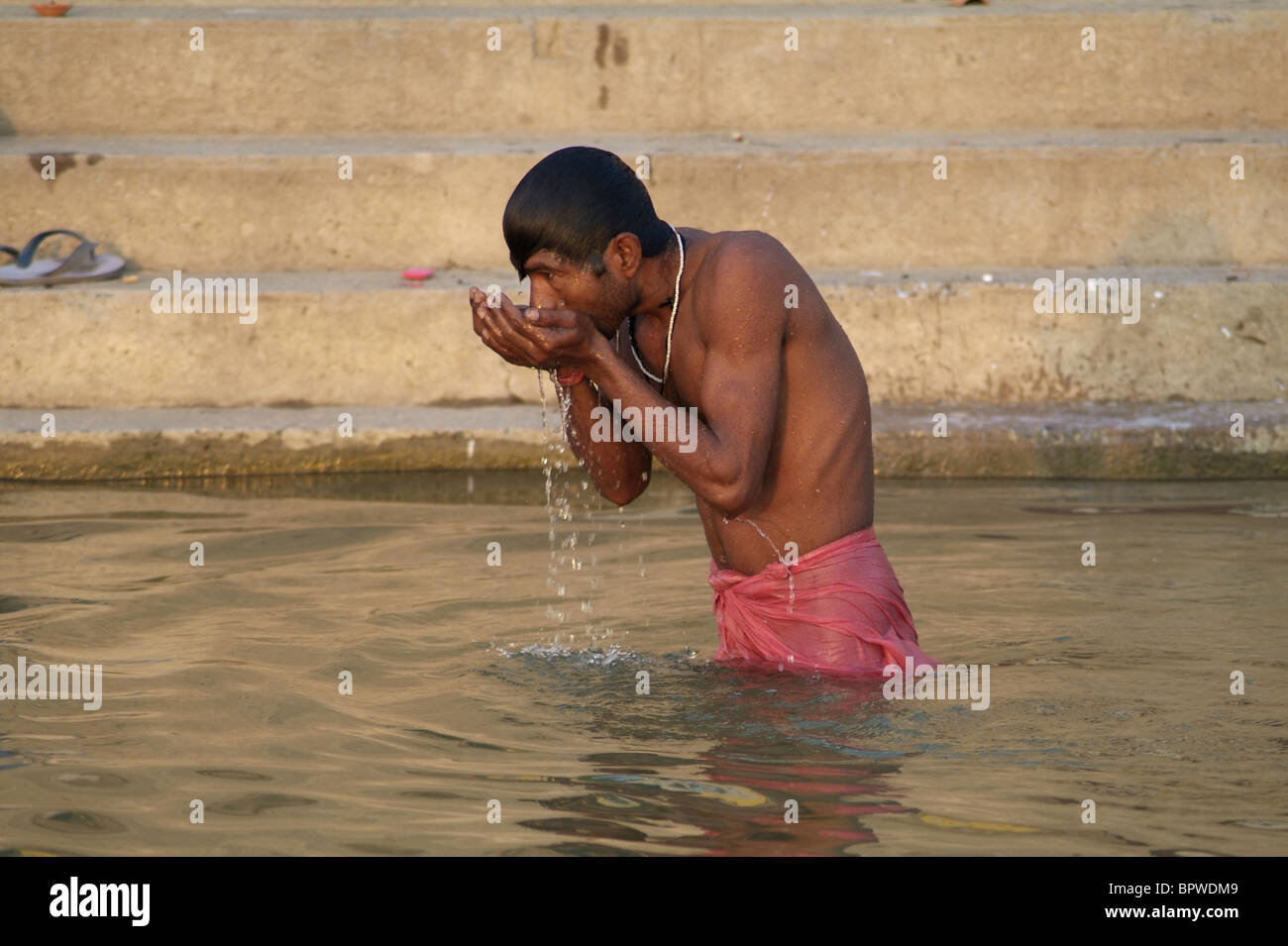 Man bathing in the holy waters of the Ganges River in Varanasi, India