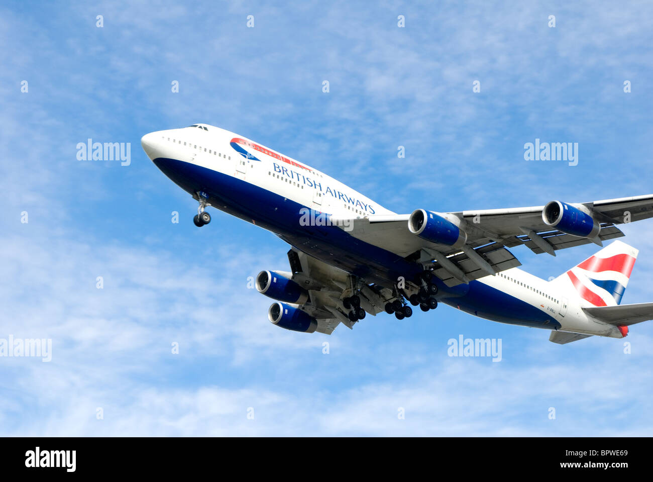 British Airways passenger jet plane flying against blue sky Stock Photo