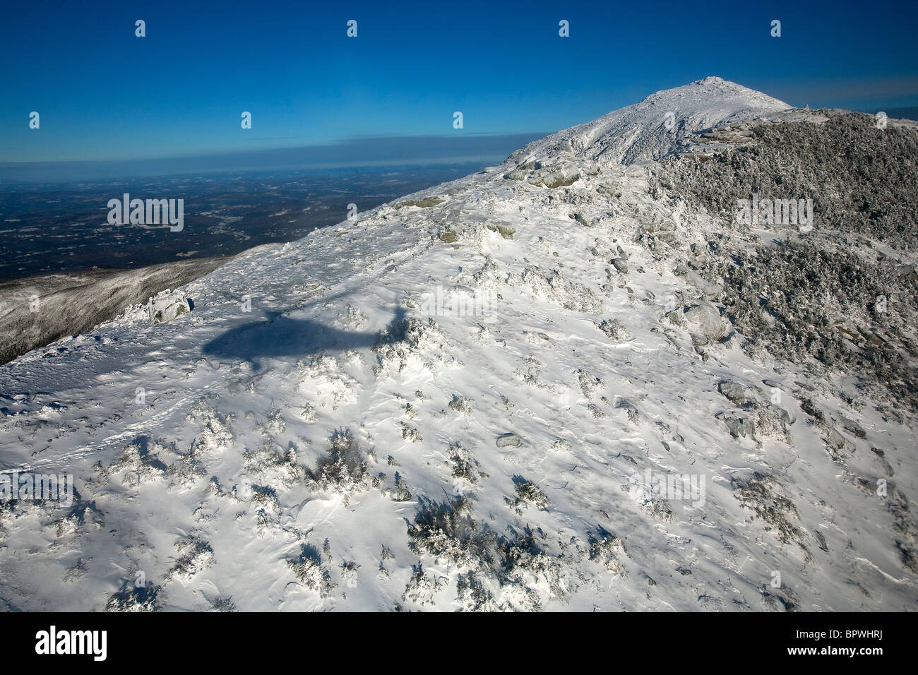 A search and rescue helicopter casts a shadow over Mount Lafayette during a training search and rescue mission. Stock Photo