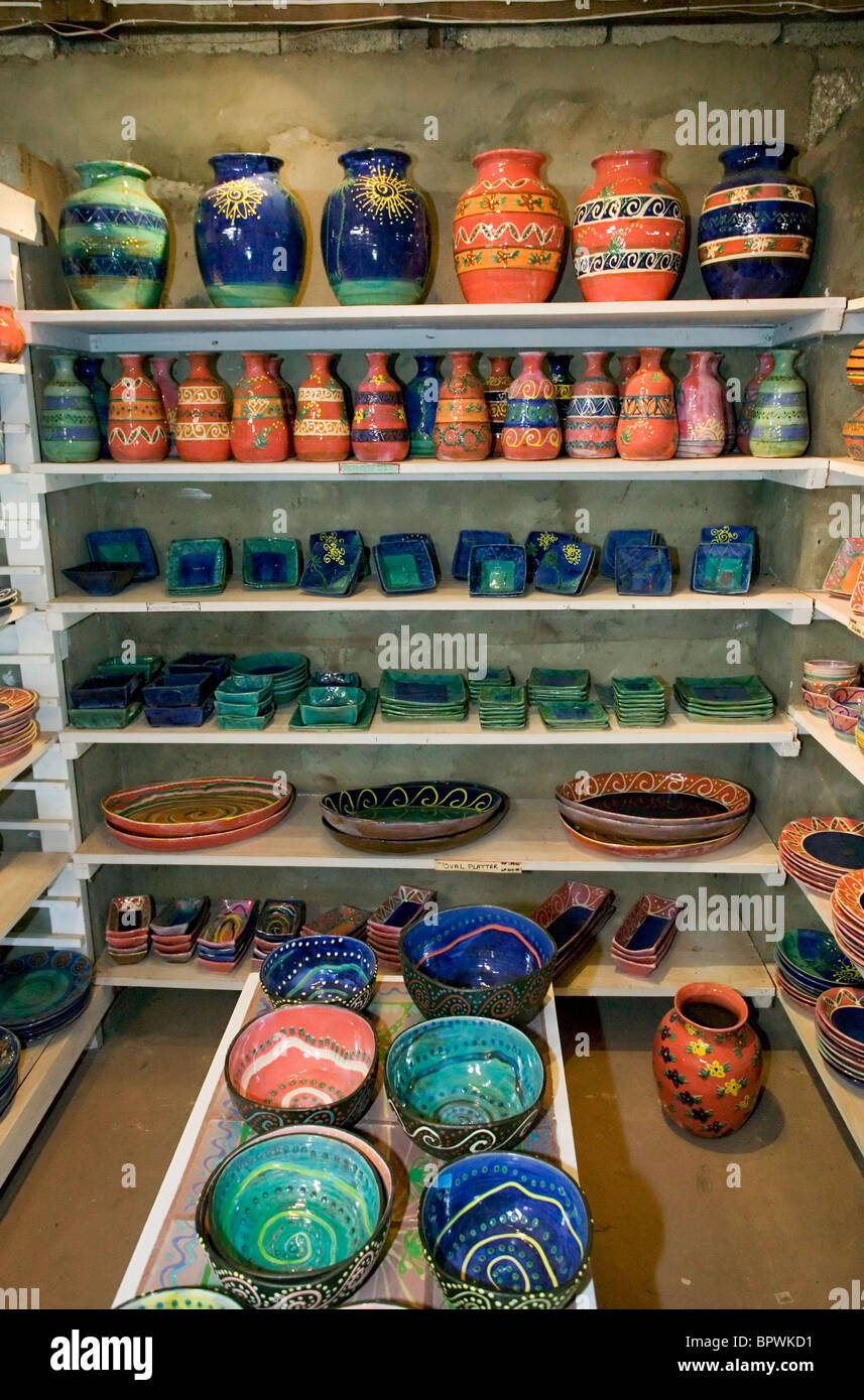 Shelves of colourful pottery for sale in the studio at the Earthworks