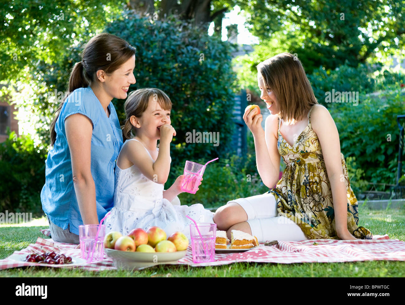 Happy mother and daughters at picnic Stock Photo - Alamy