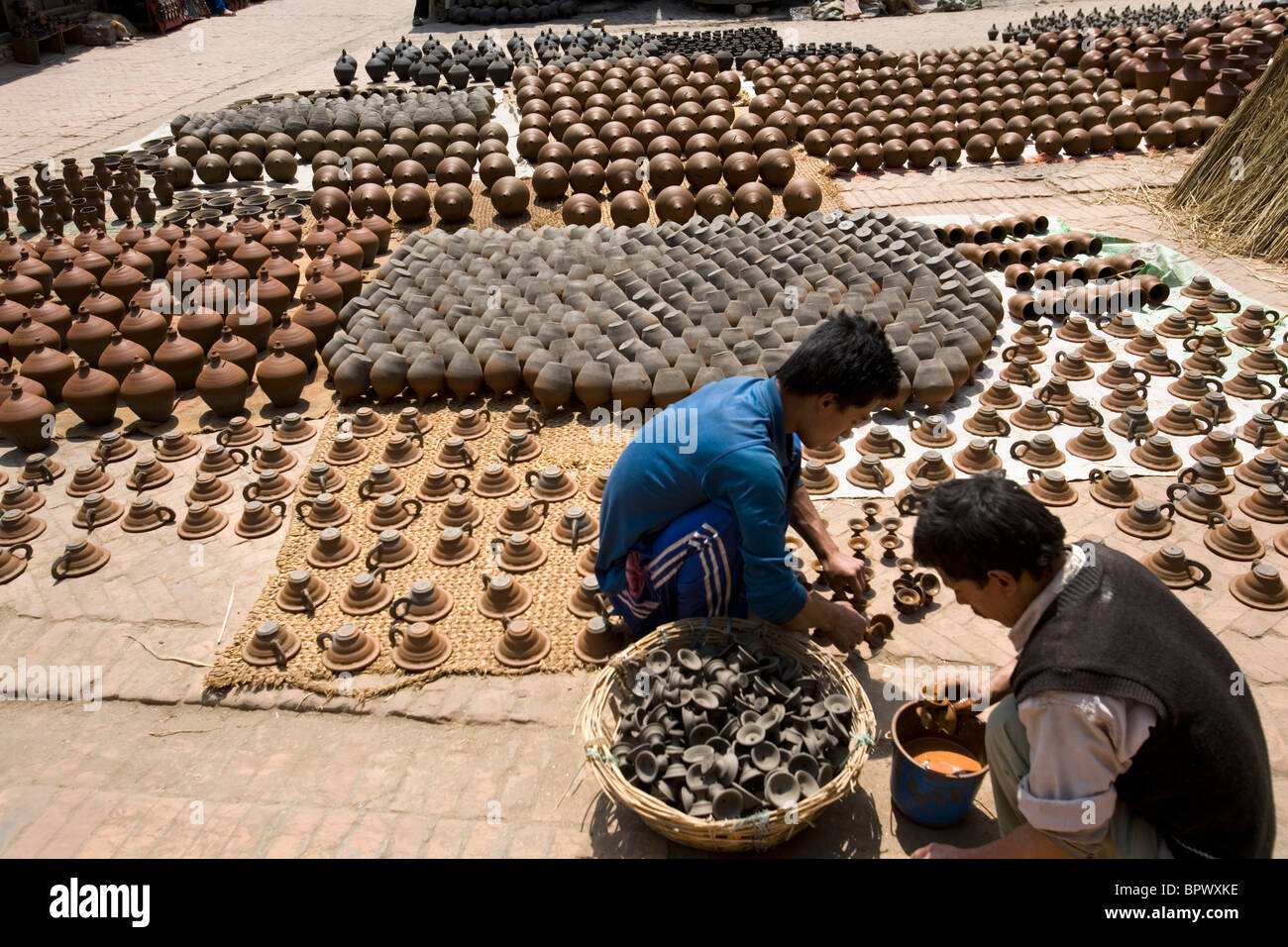 Local people putting clay pottery to dry at Potter's Square, Bhaktapur, Nepal, Asia Stock Photo