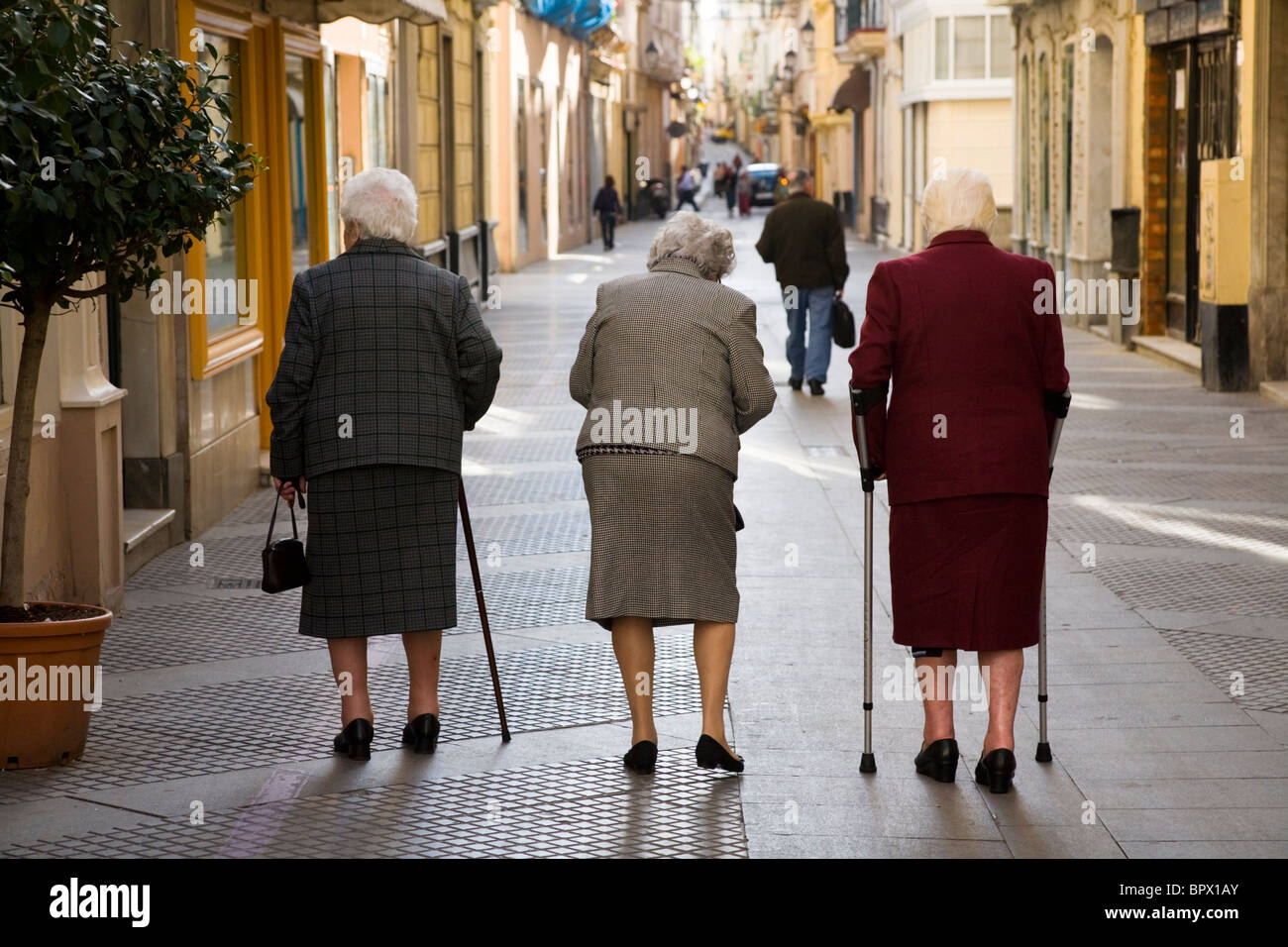 Three old / elderly / senior OAP women walking down the street. Stock Photo