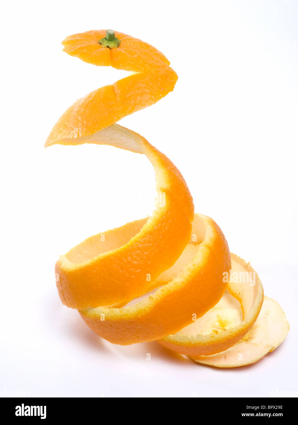 Spiral peeled bark of a ripe orange isolated on white background. Stock Photo