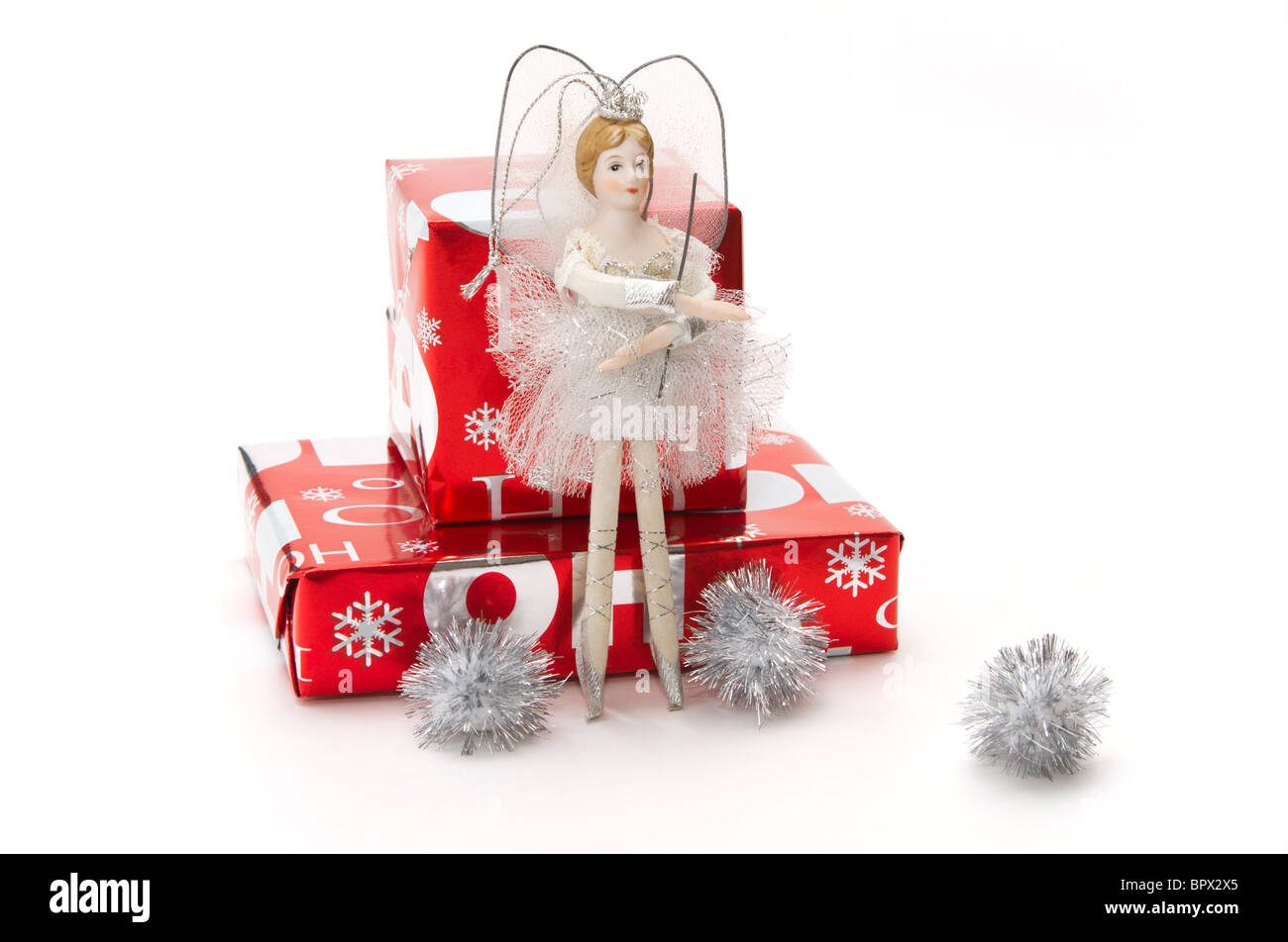 A white and silver treetop fairy with red and silver wrapped Christmas presents and silver pompons Stock Photo