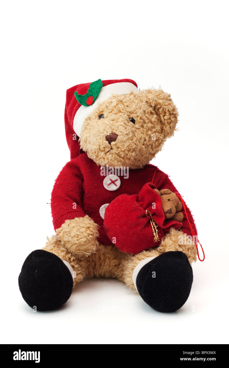 Teddy at Christmas. Well loved child's teddy bear dressed as Santa Claus. Stock Photo