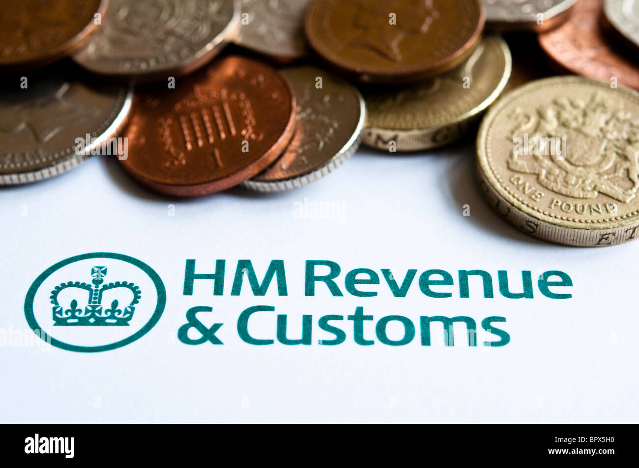 Close up view of Coins, and a UK, HMRC Tax Form / Return. Stock Photo