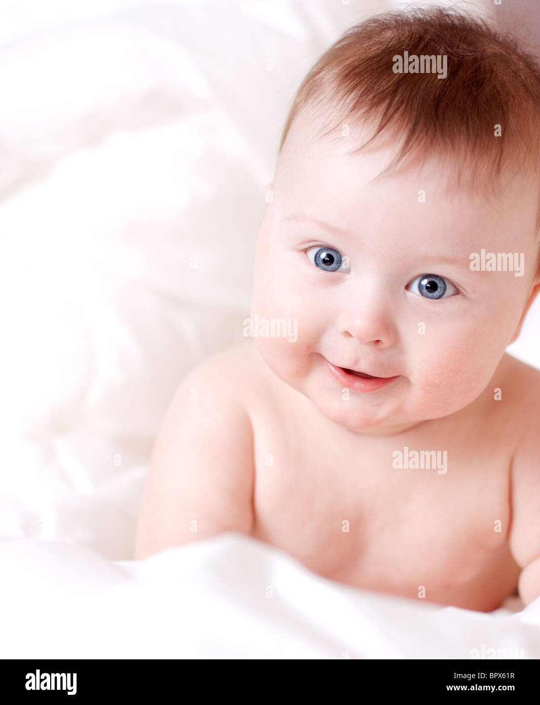 beautiful smiling baby boy on white badsheet Stock Photo - Alamy