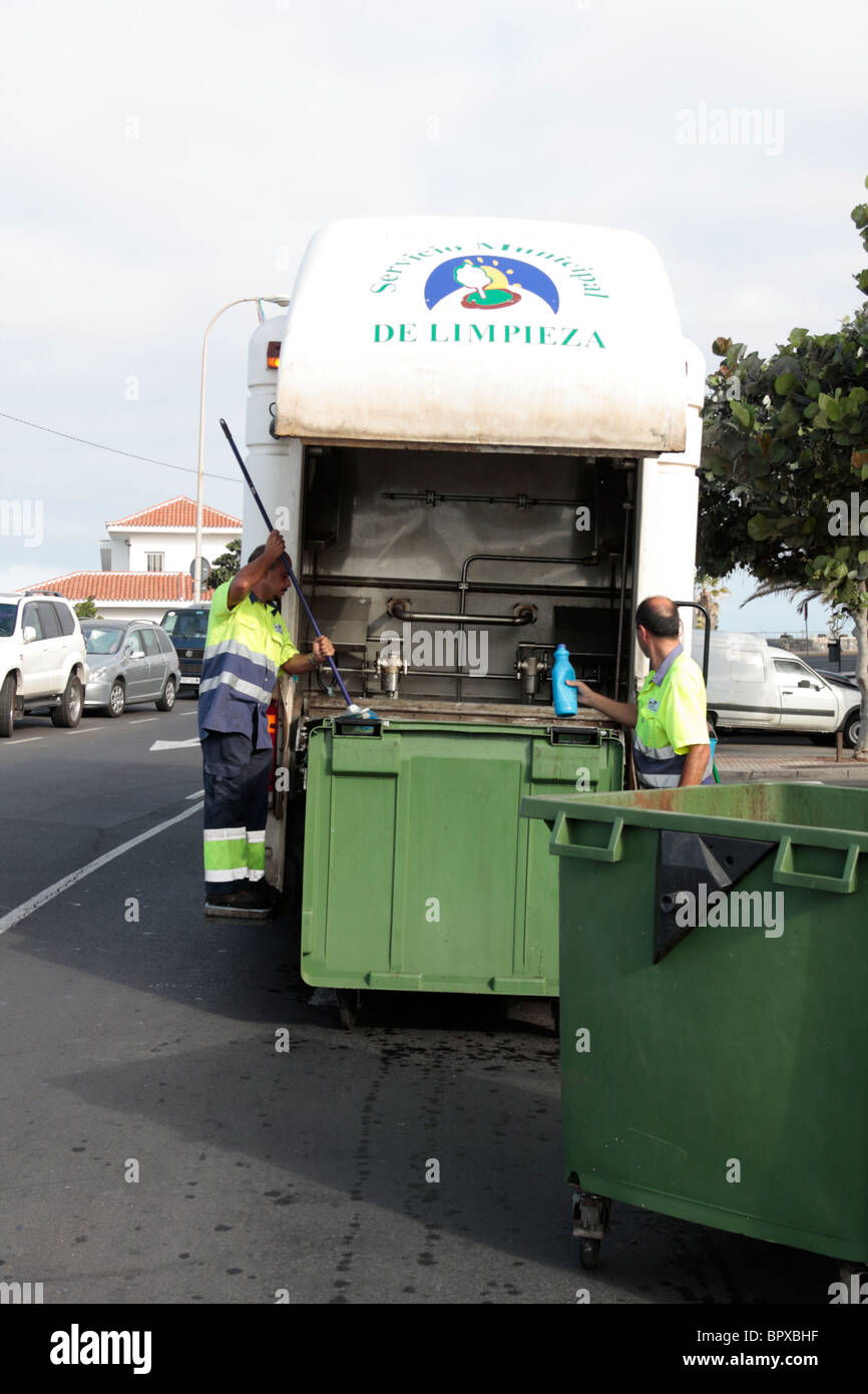 Council binmen clean and disinfect a large green wheelie bin in the street at Playa San Juan Tenerife Stock Photo