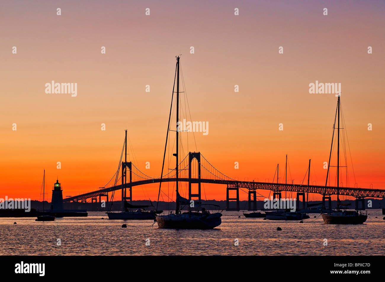 Goat Island lighthouse and the Jamestown or Pell Bridge at sunset, Newport, RI, Rhode Island Stock Photo