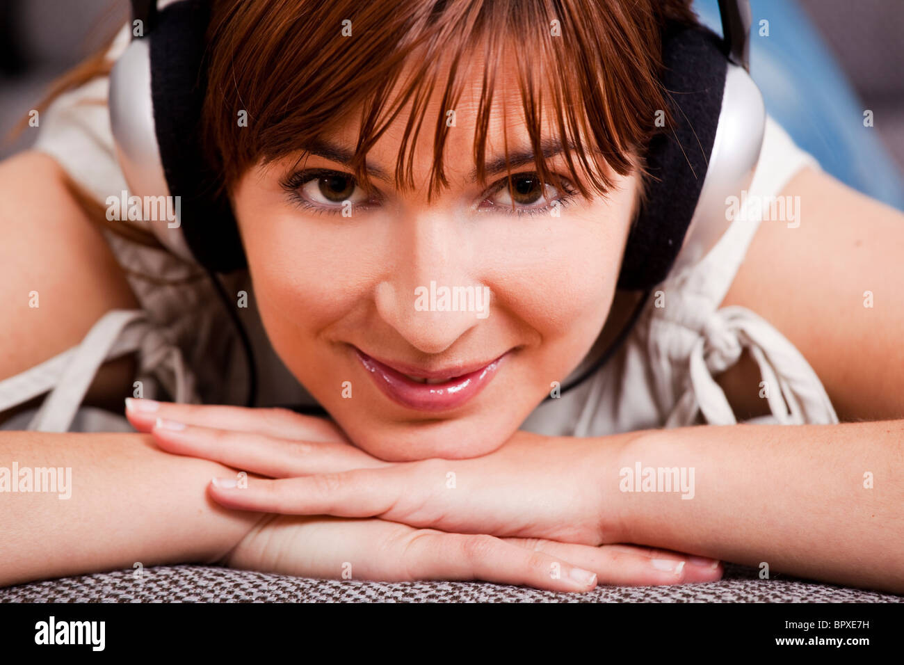 Close-up portrait of a beautiful young woman listening music with ...
