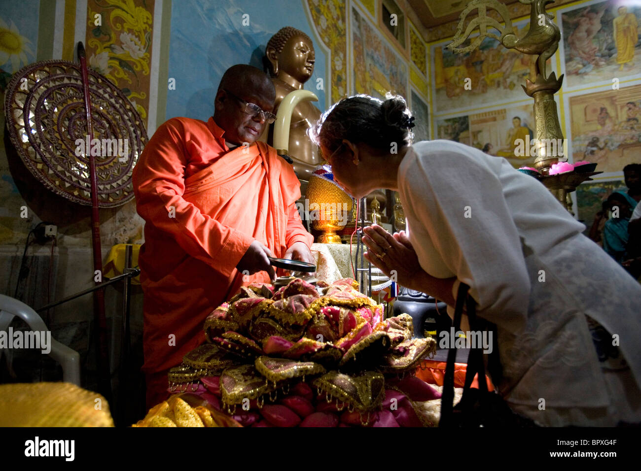 Head monk Saddhaloka from Theravada Buddhism is showing a relics to a pilgrim from Sri Lanka, Shravasti, Uttar Pradesh India. Stock Photo