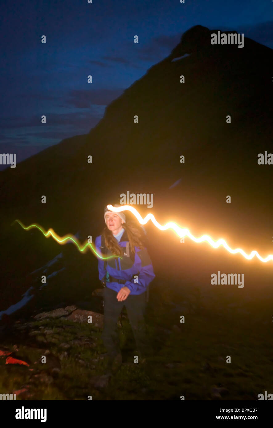 Female hiker hiking at night with a headlamp at 12,000 feet near Willow Lake in the Maroon Bells - Snowmass Wilderness near Aspe Stock Photo