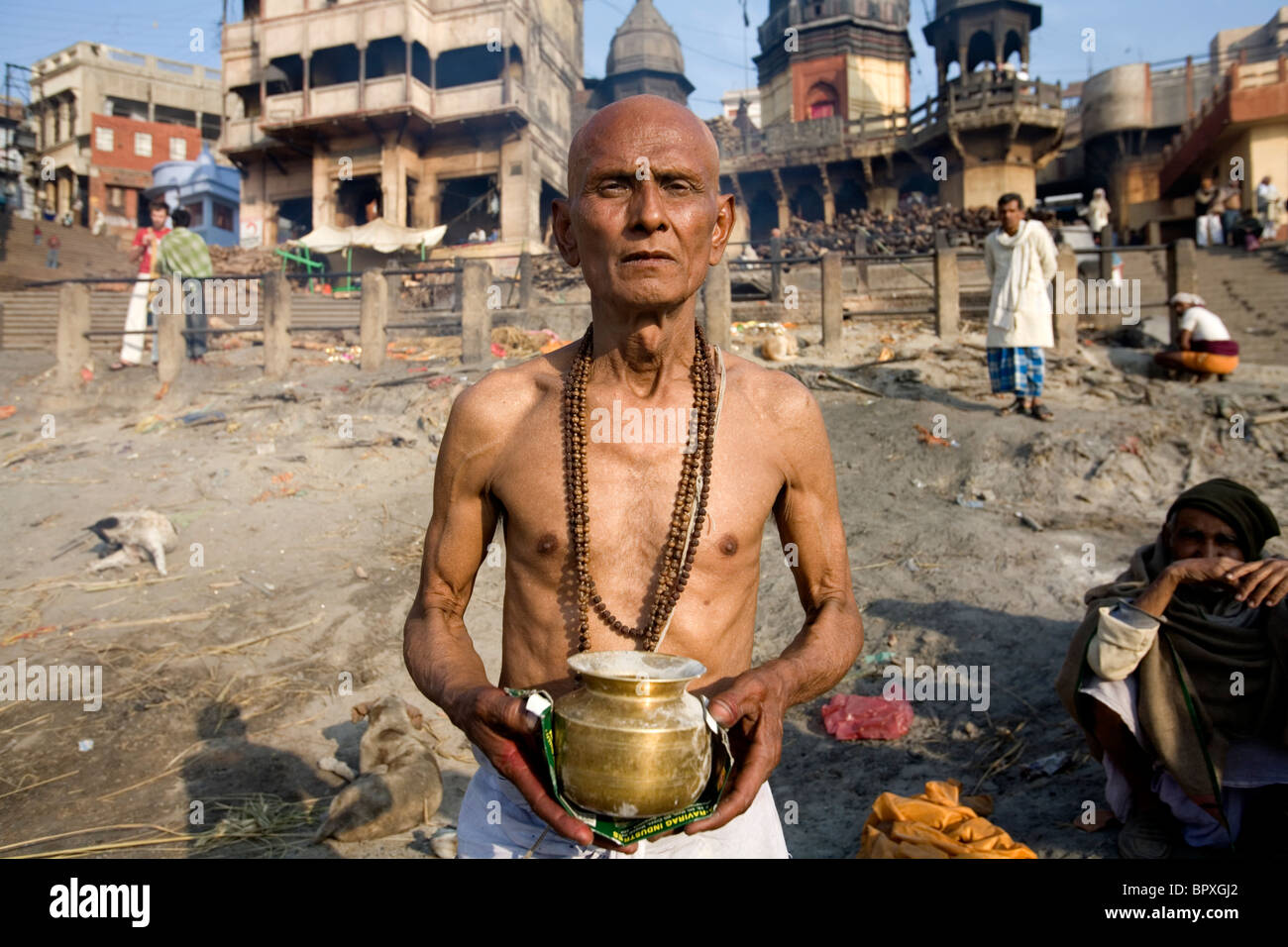 Indian man holding the ashes of his father soon after his cremation, Manikarnika burning ghat, Varanasi, Uttar Pradesh, India. Stock Photo