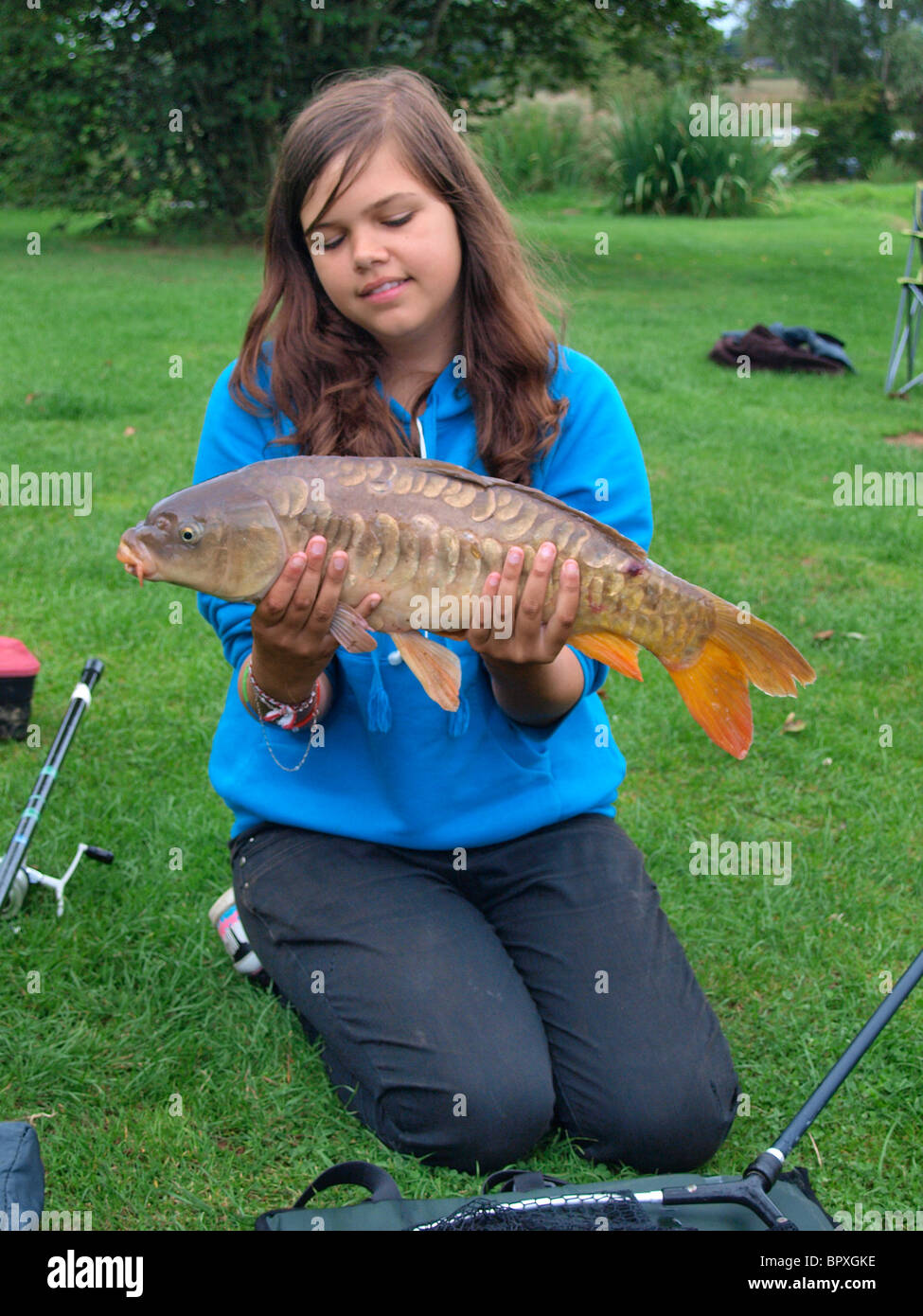 Teenaged girl with large carp fish she caught, Devon, UK Stock