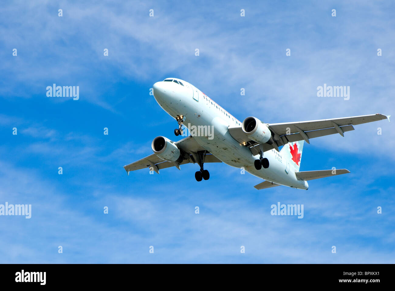 Air Canada plane with landing gear down coming in for final approach to airport Stock Photo