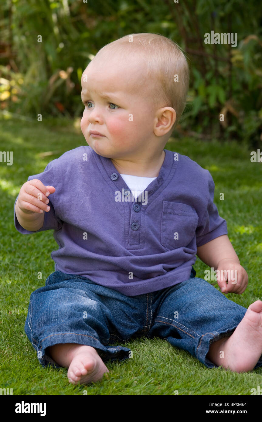 Baby boy sitting up in the garden Stock Photo - Alamy