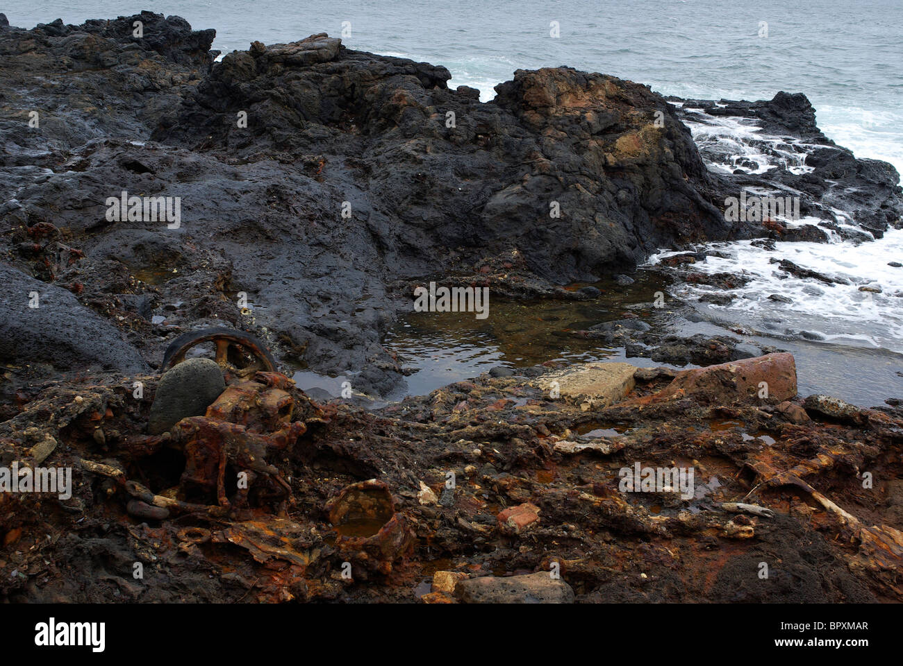 trash litters the shore of Glass Beach in Hawaii. Glass