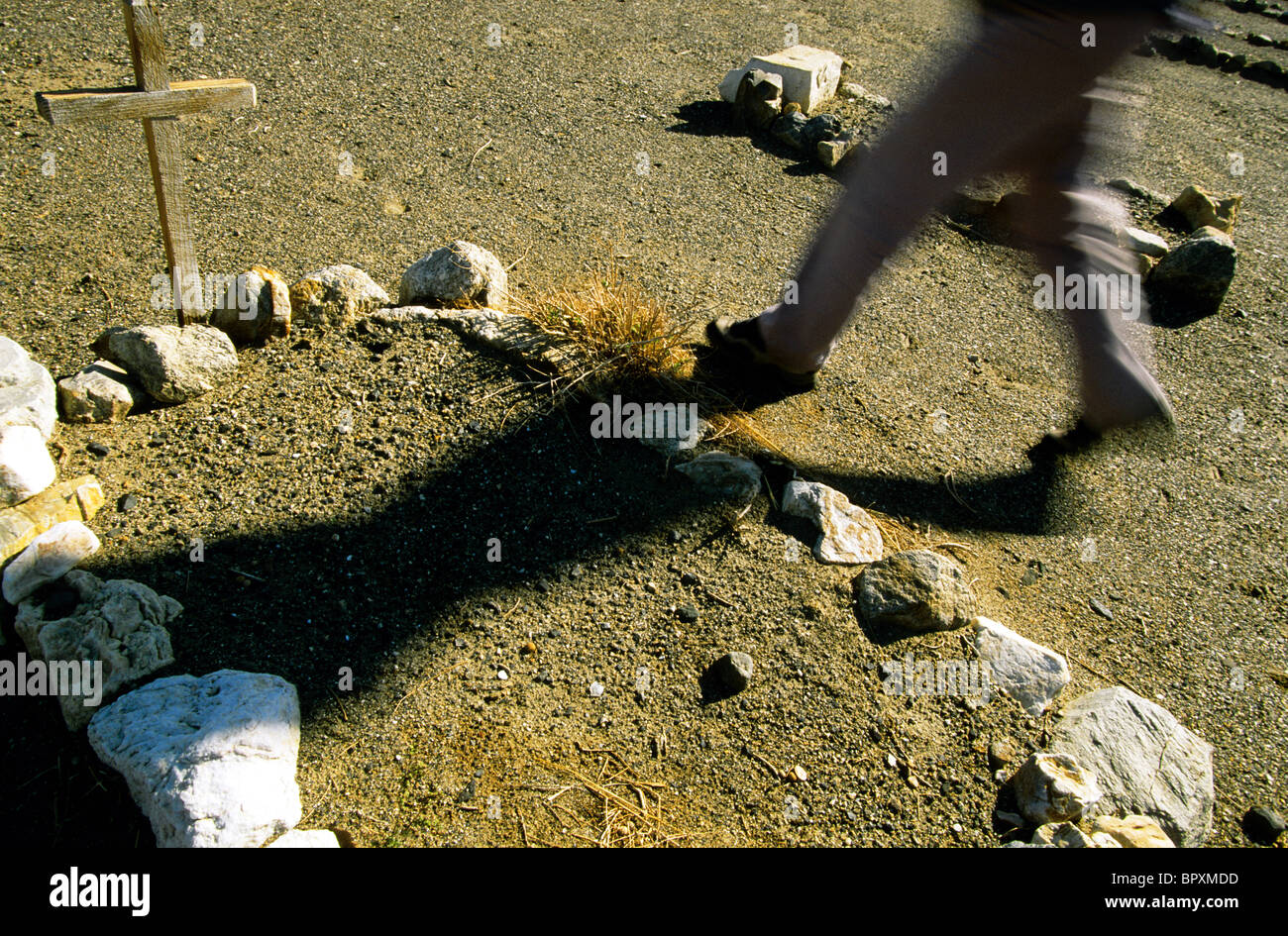 A woman walks by a grave, ghost town of Ballarat, California. Stock Photo