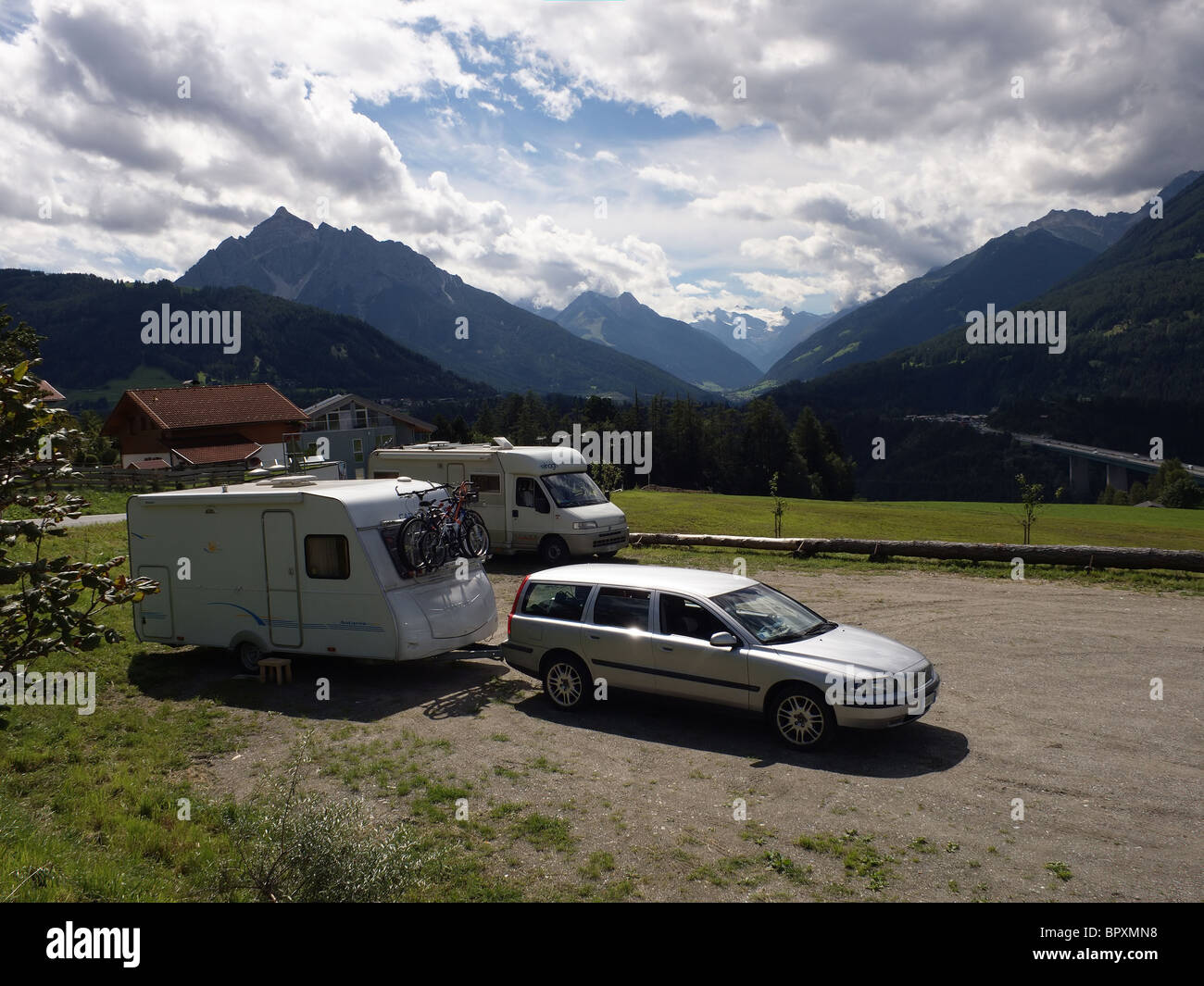 A touring caravan and a motor caravan parked near the Brenner Pass with the Stubai Valley and the Europa Bridge behind Stock Photo
