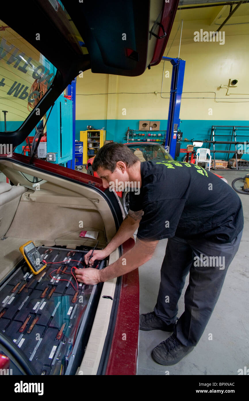 A technician at a California vehicle modification shop checks the voltage of a Toyota Prius hybrid car's main driving battery Stock Photo