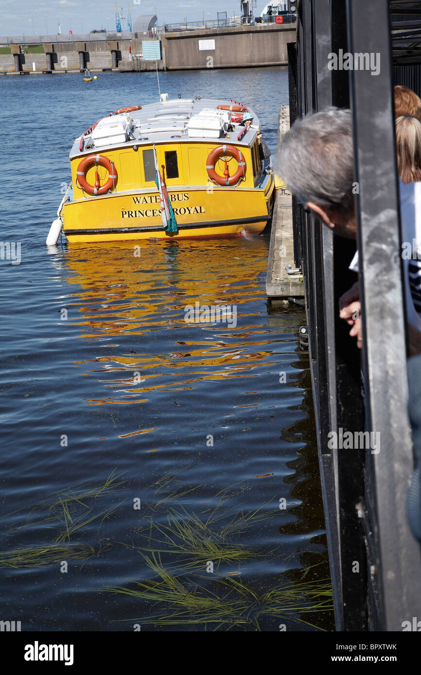 People waiting to board a waterbus at Cardiff bay, Wales. Stock Photo