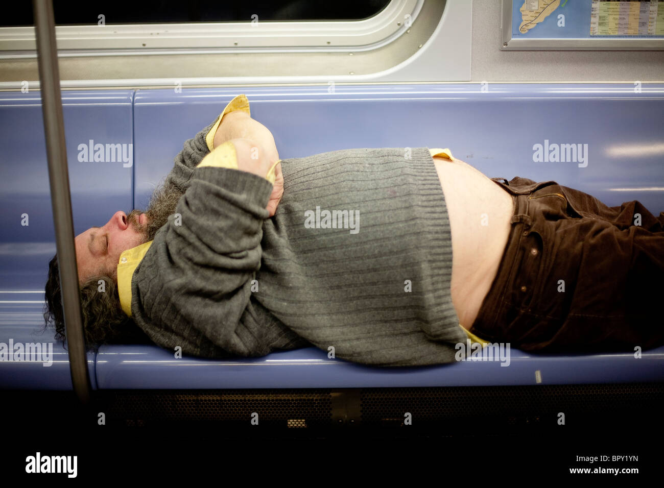 Man sleeping on bench in New York City Subway car Stock Photo
