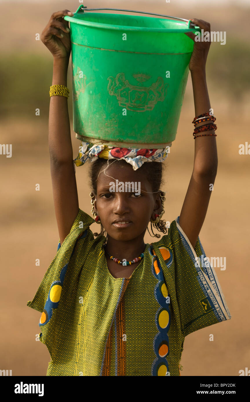 Peul girl fetching water from the senegal river, Senegal Stock Photo