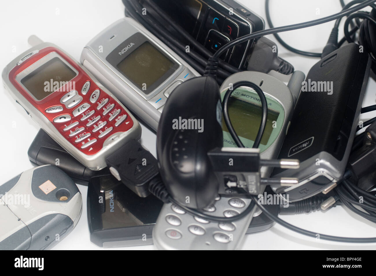 A pile of old disused mobile phones and chargers Stock Photo