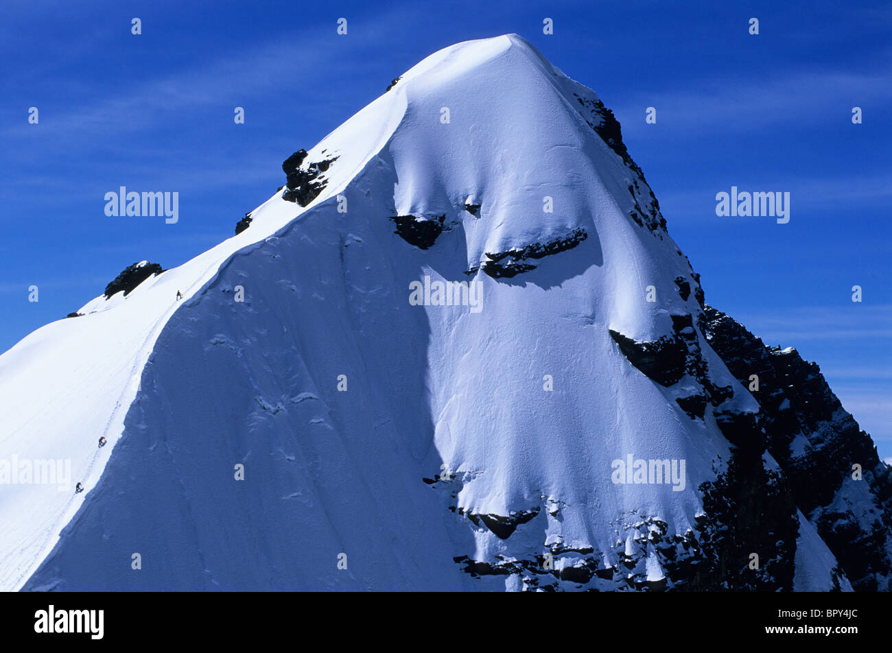 A mountain climbing team approaches the summit of Pequeno Alpamayo, Cordillera Real, Bolivia Stock Photo