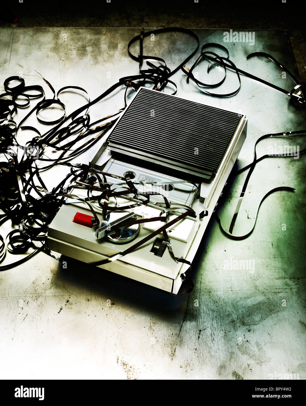 vintage old tape recorder with scrambles tapes shot on distressed metallic background Stock Photo