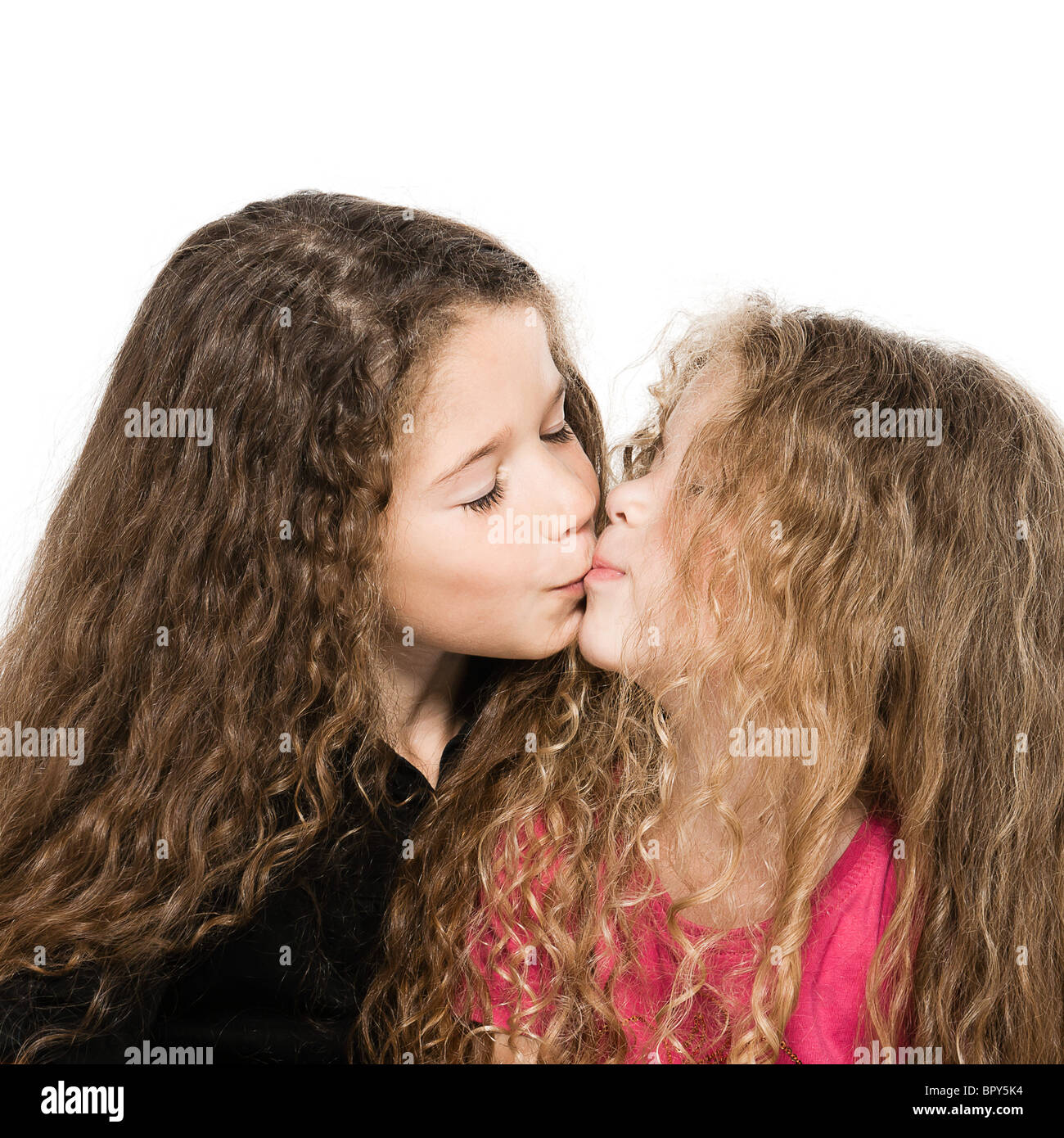 two caucasian little girls portrait kissing isolated studio on white background Stock Photo