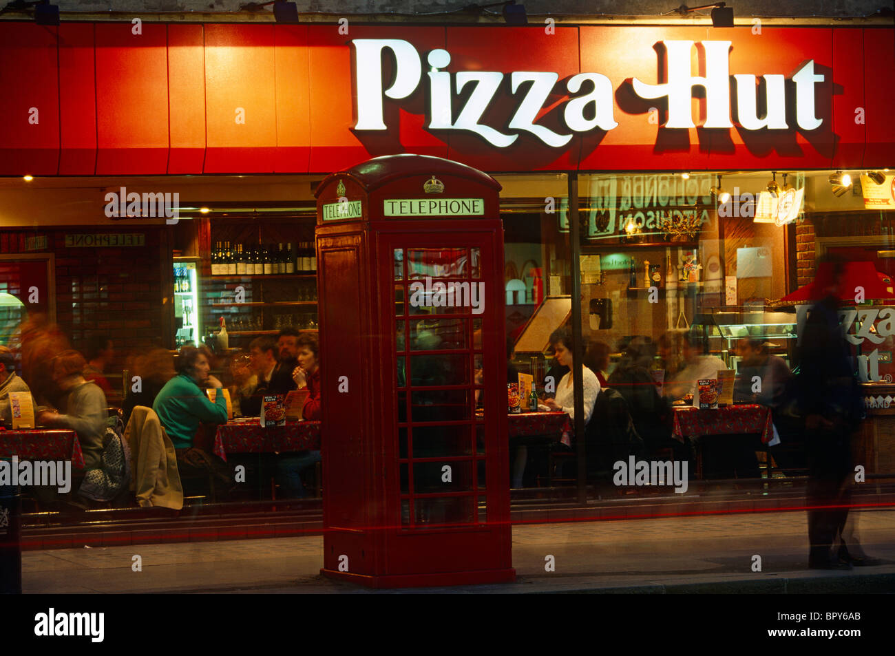 Pizza Hut restaurant chain and red phone box at night in central
