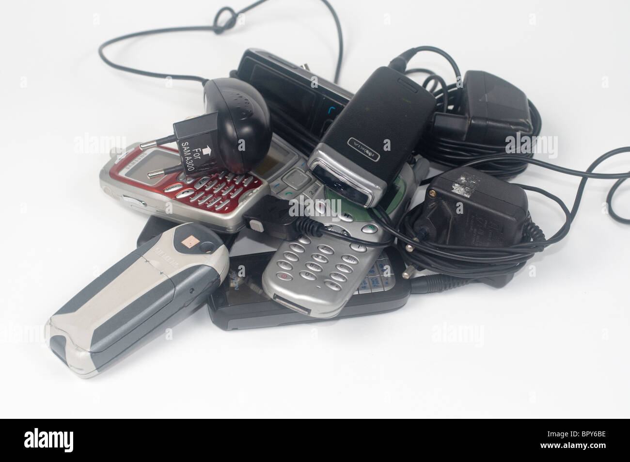 A pile of old disused mobile phones and chargers Stock Photo