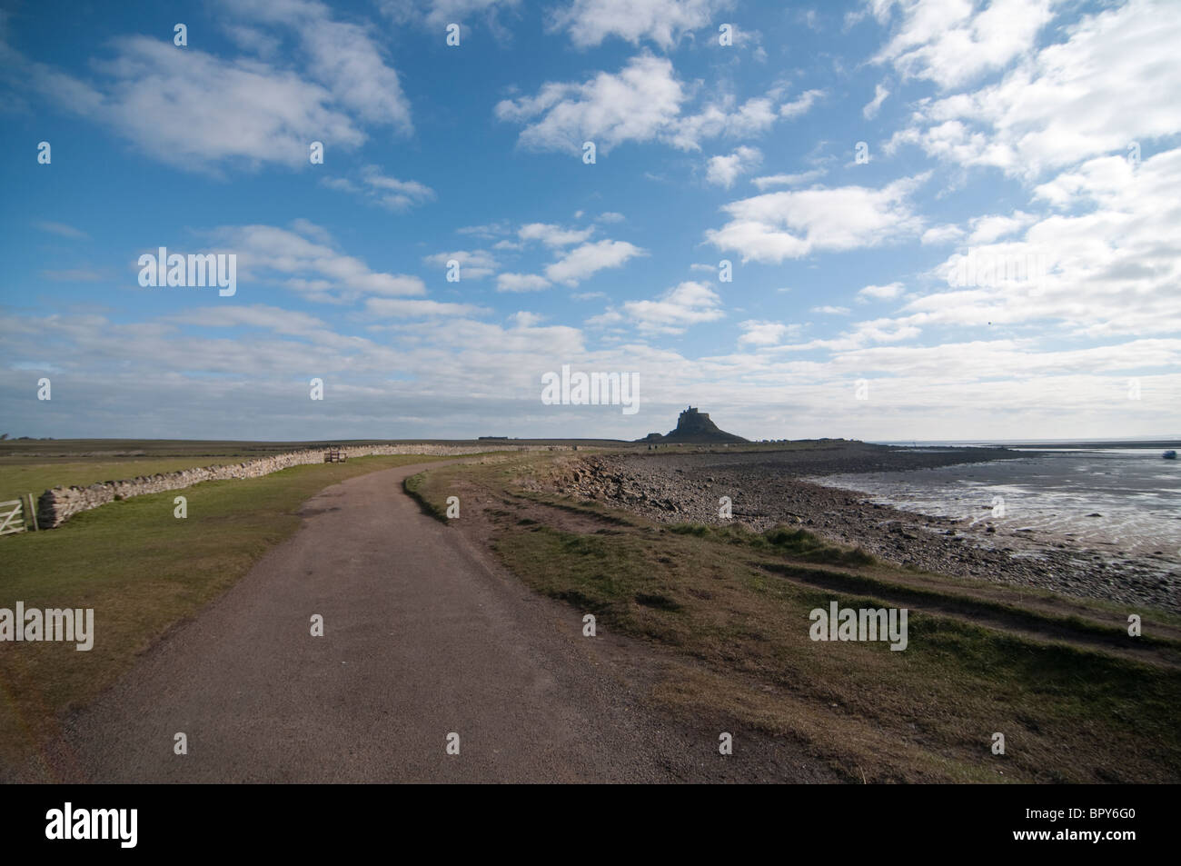 The distant castle of Lindisfarne on Holy Island along the North Sea in Northumberland, England. Stock Photo