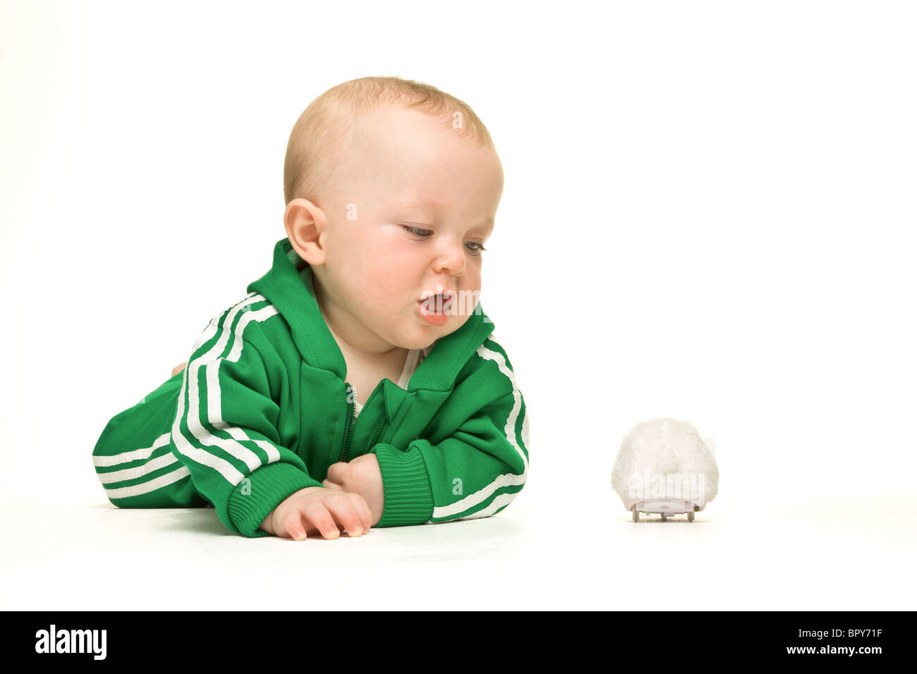 Cute expressive baby boy isolated on white background playing with toy mouse. Stock Photo